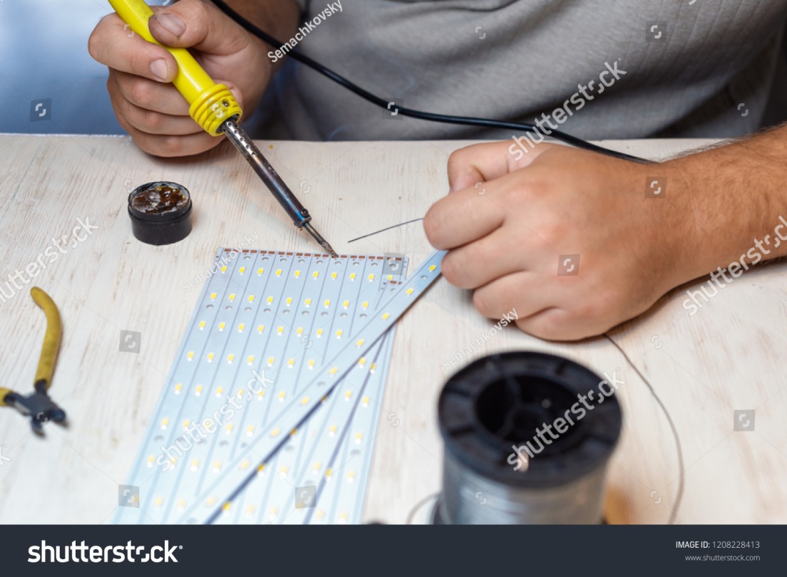 stock-photo-man-s-hands-holding-soldering-iron-tool-repairing-led-strip-lights-1208228413.jpg