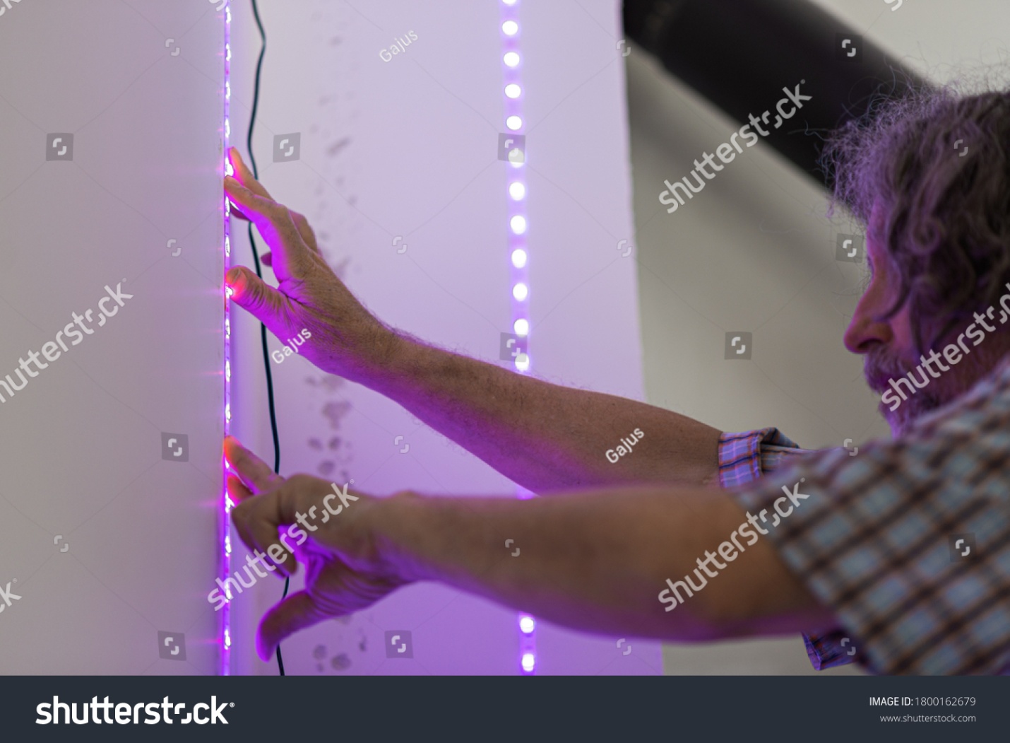 stock-photo-senior-male-electrician-placing-decorative-led-lights-stripe-on-a-wall-1800162679.jpg