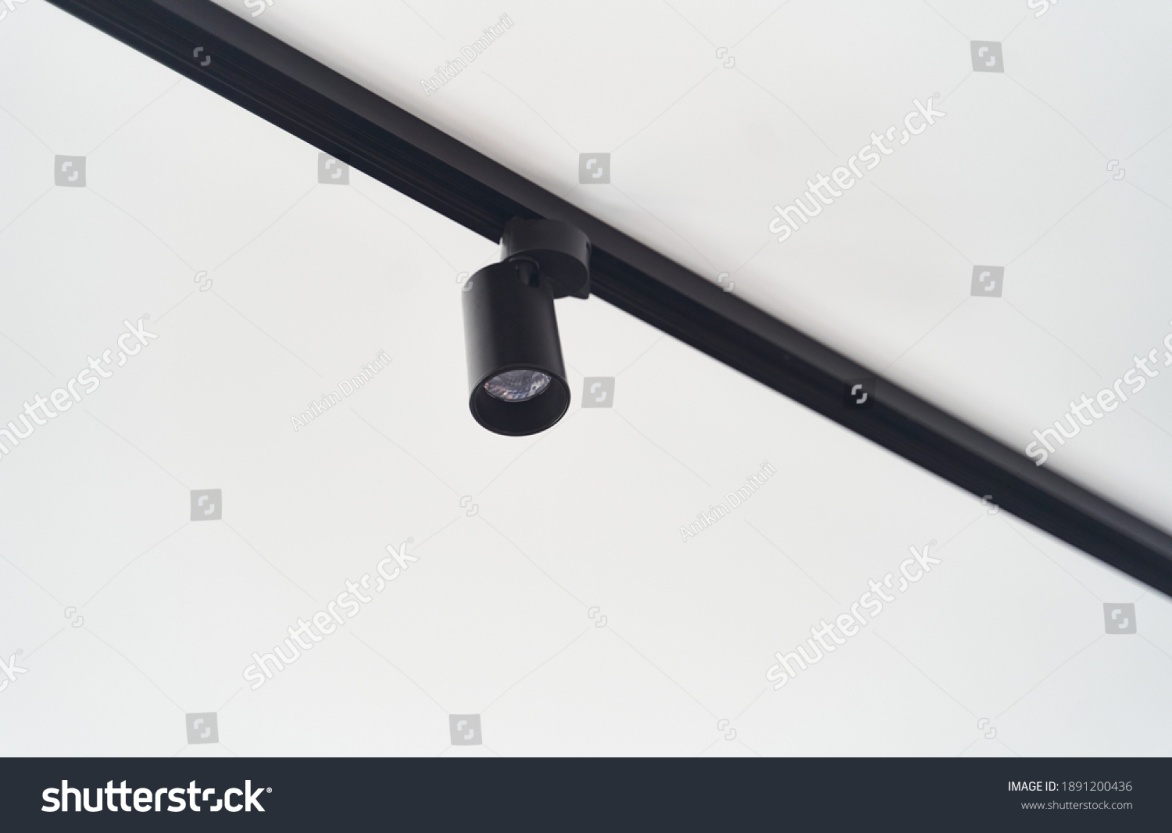 stock-photo-modern-led-black-track-spot-lights-in-the-interior-hanging-lamps-spotlights-attached-to-a-concrete-1891200436.jpg